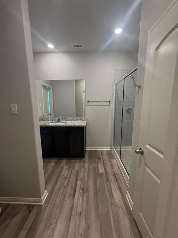 310 Foster Lane Anna, TX 75409 - Photo 12 of 15 Bathroom featuring wood-finish flooring and a dark wood vanity with a light-colored countertop