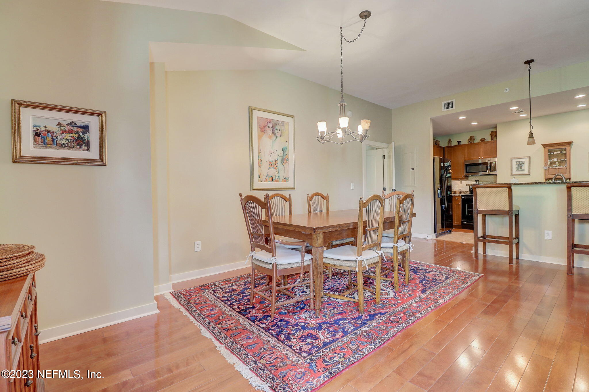 965 Registry Boulevard, Unit 307 St. Augustine, FL 32092 - Photo 9 of 31 a dining room with wooden floor a chandelier a wooden table and chairs