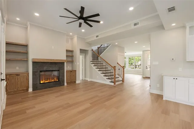 an empty room with wooden floor a fireplace and entryway