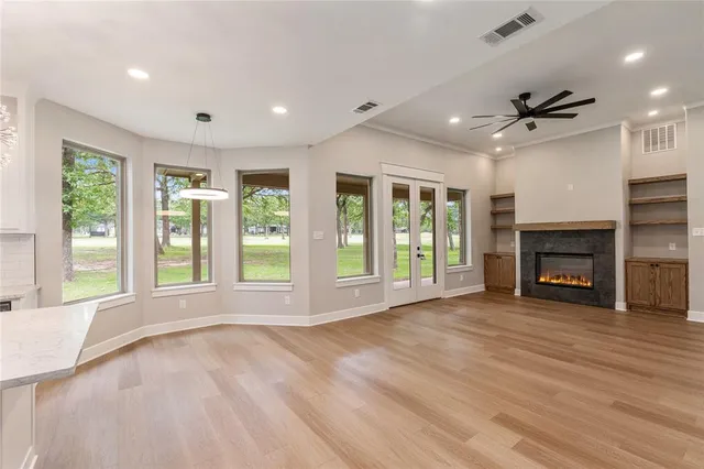 a view of an empty room with a fireplace and a window