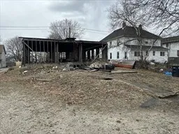 a view of a house with a trees and wooden fence