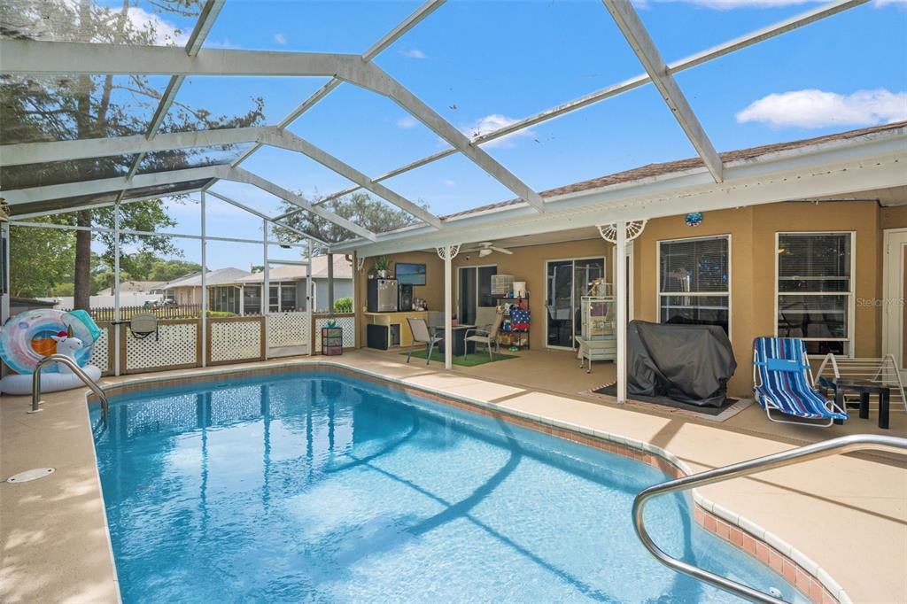 12292 Ronald Street Spring Hill, FL 34609 - Photo 14 of 18 a view of a patio with table and chairs under an umbrella