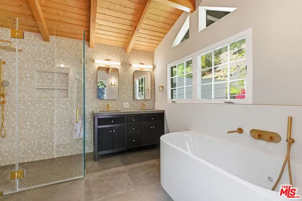 a spacious bathroom with a tub sink and mirror