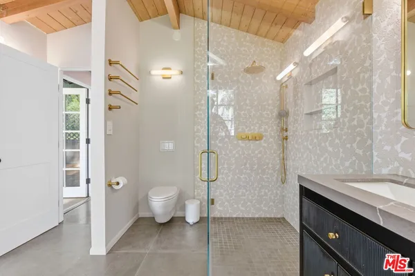 a bathroom with a granite countertop sink a toilet and shower