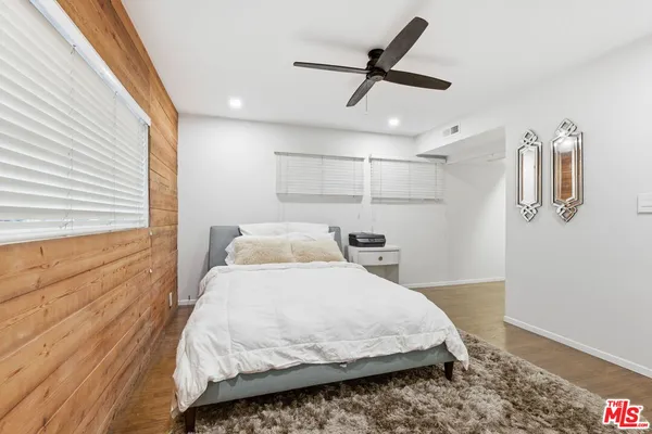 a bedroom with a bed and a ceiling fan