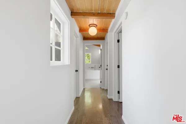 a view of a hallway with wooden floor and front door
