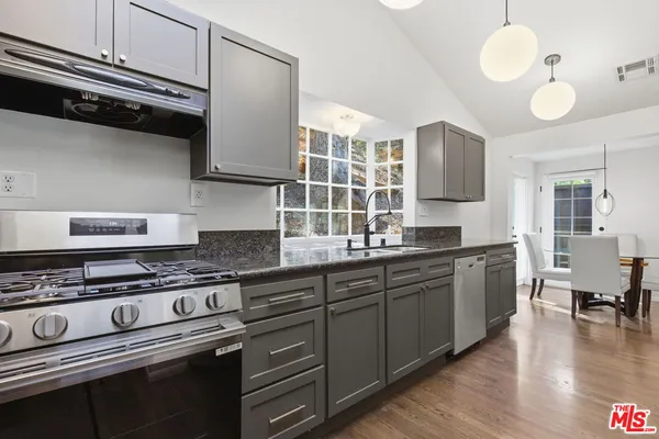 a large kitchen with stainless steel appliances granite countertop a stove and a sink