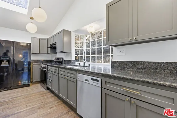 a kitchen with stainless steel appliances granite countertop a sink a stove cabinets and entryway