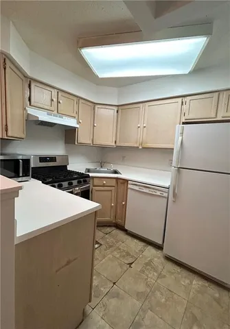 a kitchen with white cabinets and white appliances