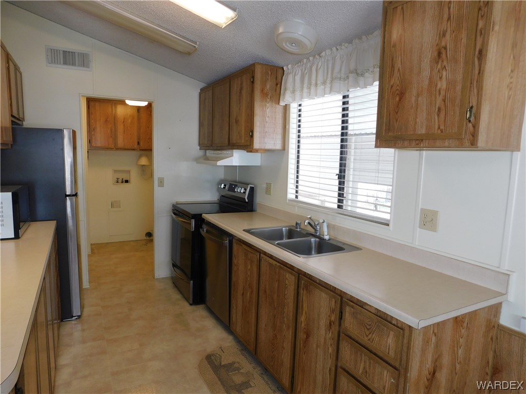 3003 Hualapai Mountain Road, Unit 55 Kingman, AZ 86401 - Photo 25 of 38 a kitchen with a sink stove and refrigerator
