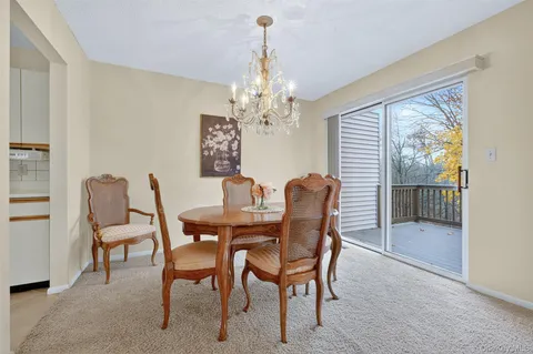a dining room with furniture a chandelier and window