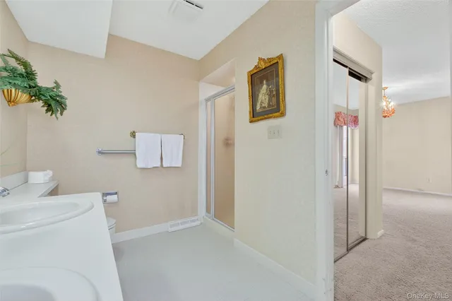 a bedroom with a bed a chandelier and dresser