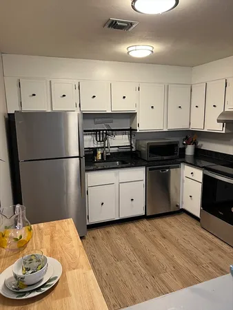 a kitchen with stainless steel appliances granite countertop a refrigerator sink and cabinets