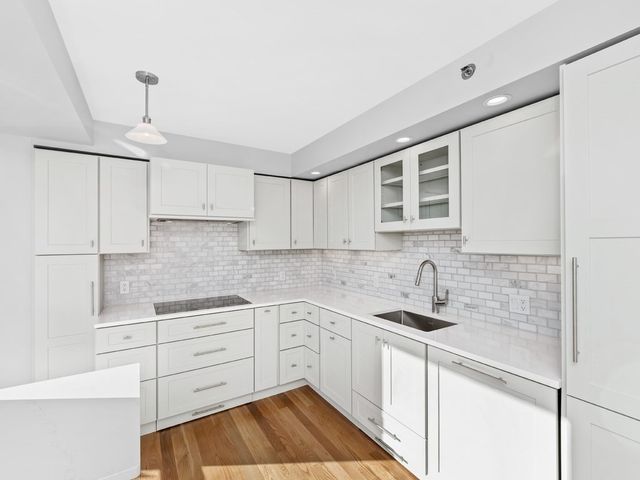 a kitchen with granite countertop white cabinets and white appliances