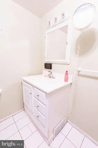 a bathroom with a sink vanity and a mirror