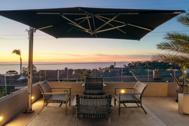 an outdoor sitting area with furniture and umbrella