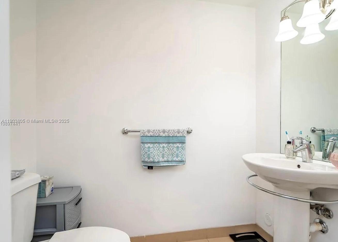 300 South Biscayne Boulevard, Unit L1208 Miami, FL 33131 - Photo 5 of 10 a bathroom with a sink mirror and toilet