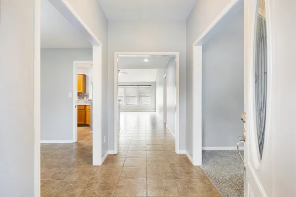 a view of a hallway with wooden floor and a bathroom