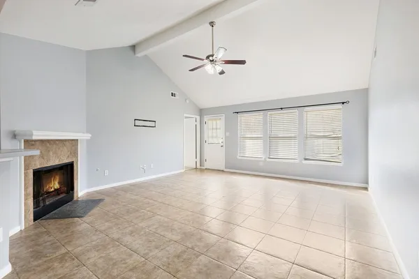 a view of an empty room with a fireplace and a window