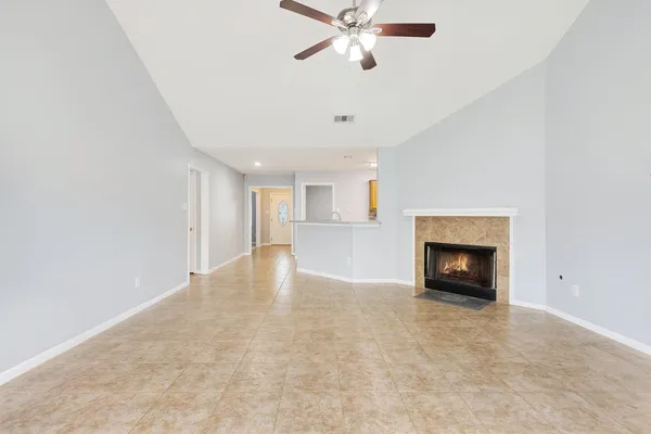 an empty room with windows and fireplace