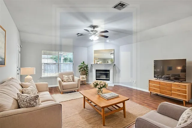 a living room with furniture a fireplace and a flat screen tv