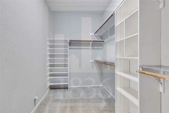 a view of walk in closet with empty racks
