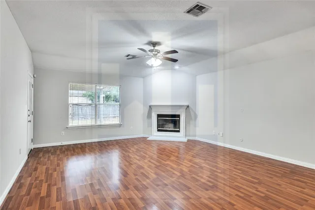 wooden floor fireplace and windows in an empty room