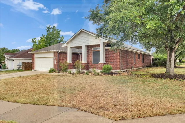 a front view of house with yard and trees around