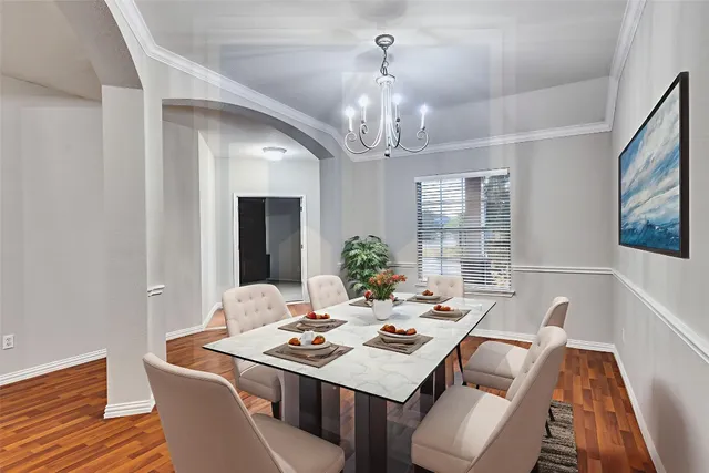 a view of a dining room with furniture a chandelier and wooden floor