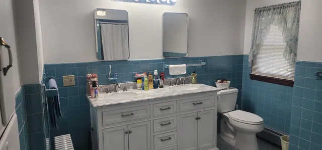 a bathroom with a granite countertop toilet sink and mirror
