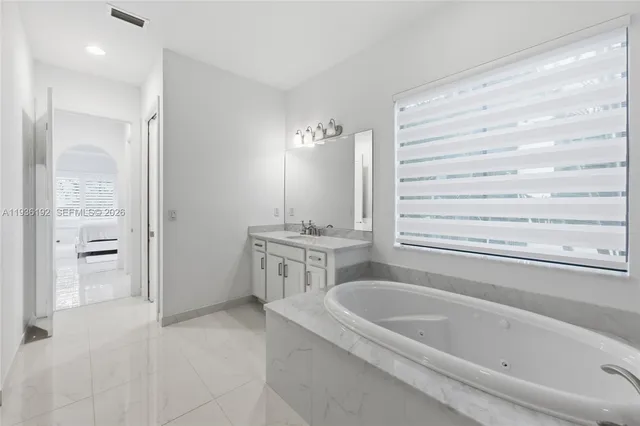 a bathroom with a tub a sink and a shower