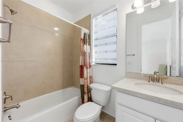 a bathroom with a granite countertop toilet a sink and a bathtub