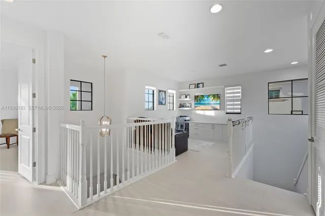 a hallway with white cabinets and wooden floor