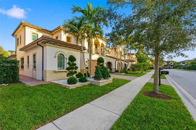 a front view of a house with a yard and potted plants