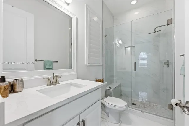 a bathroom with a sink toilet vanity and shower