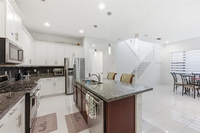 a kitchen with granite countertop kitchen island stainless steel appliances a table and chairs