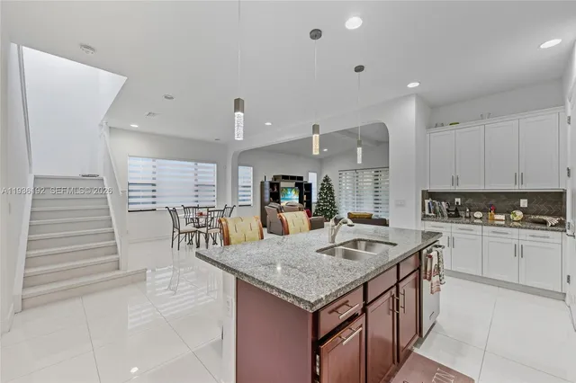 a kitchen with granite countertop kitchen island stainless steel appliances a sink and cabinets