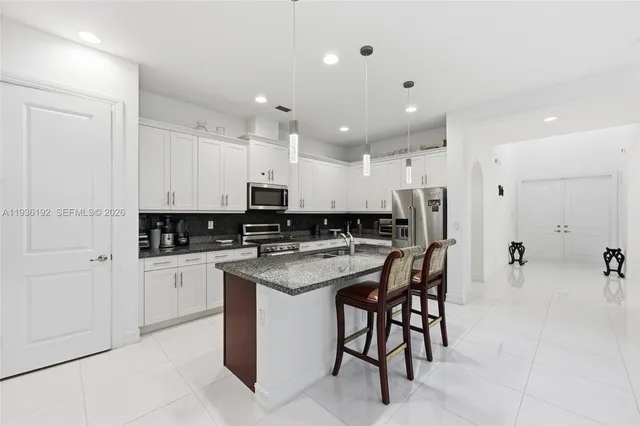 a kitchen with stainless steel appliances a sink a stove a refrigerator and cabinets