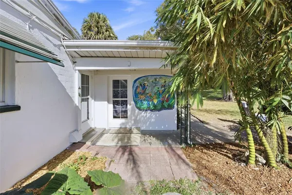 a view of house with a big yard and potted plants