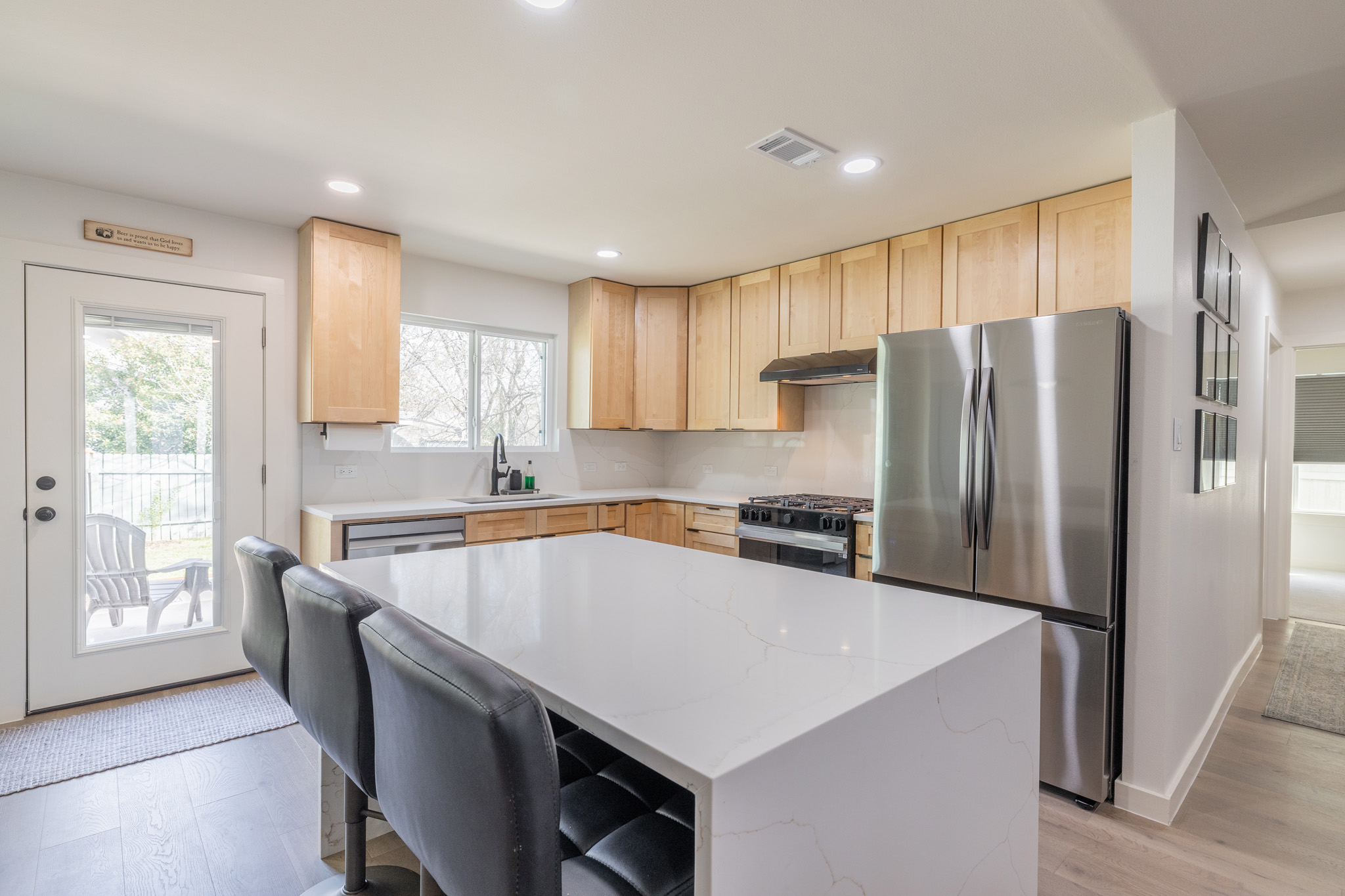 2214 Lear Lane Austin, TX 78745 - Photo 13 of 40 a kitchen with stainless steel appliances a refrigerator a sink a stove a microwave a center island and a window