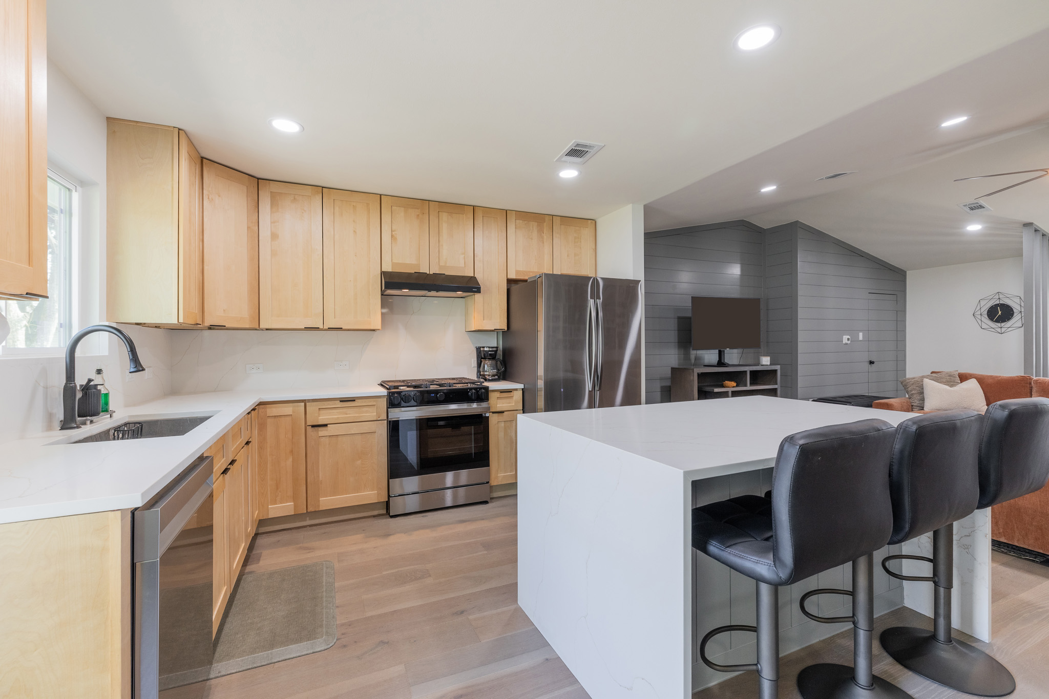 2214 Lear Lane Austin, TX 78745 - Photo 18 of 40 a kitchen with stainless steel appliances a stove a sink a refrigerator white cabinets and wooden cabinets