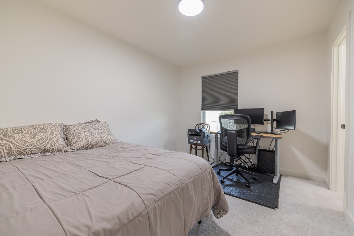 2214 Lear Lane Austin, TX 78745 - Photo 21 of 40 a bedroom with a bed a table and a chair