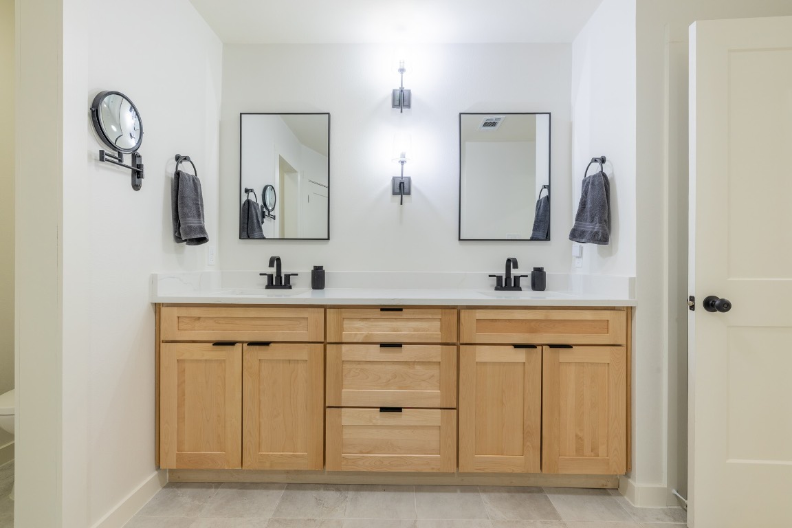 2214 Lear Lane Austin, TX 78745 - Photo 35 of 40 a bathroom with double vanity sinks and a mirror