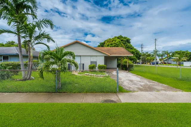 a front view of a house with a garden and yard