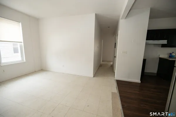 an empty room with wooden floor and a window