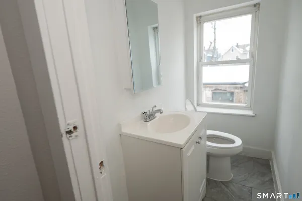 a bathroom with a sink toilet and a window