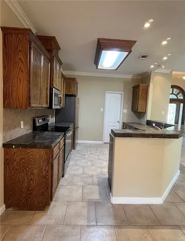 a kitchen with kitchen island granite countertop a sink and a stove top oven