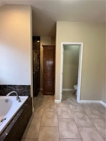 a spacious bathroom with a tub sink and mirror