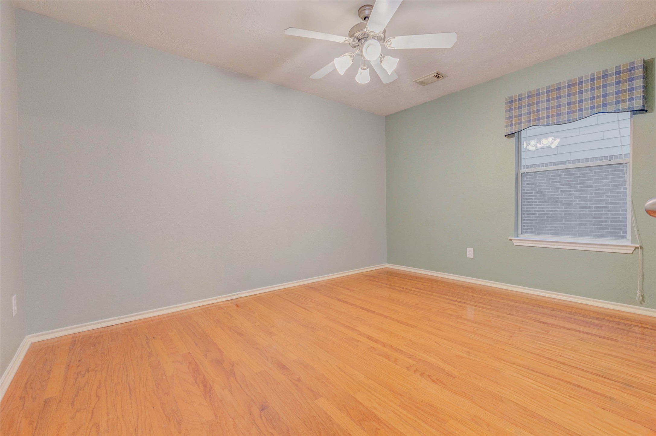 2326 Fern Lacy Drive Spring, TX 77388 - Photo 25 of 31 Spacious secondary bedroom with wood-look flooring, ceiling fan, and bright window views.