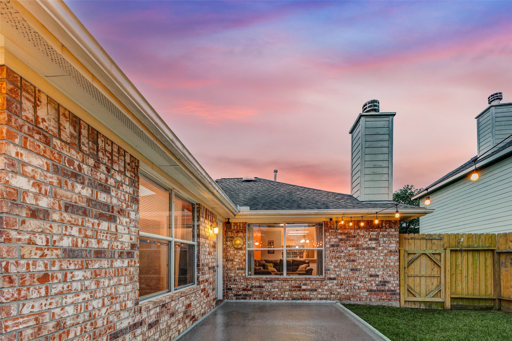 2326 Fern Lacy Drive Spring, TX 77388 - Photo 28 of 31 Private patio view with glowing interior light and charming twilight atmosphere.